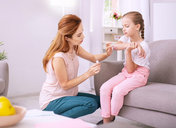 mujer curando herida de niña