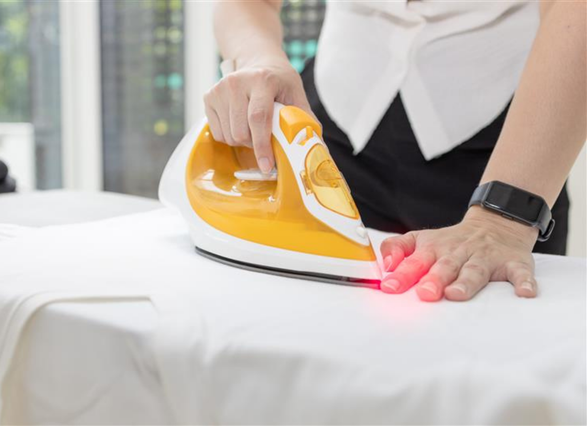 Mano cogiendo una plancha con quemadura en la otra mano